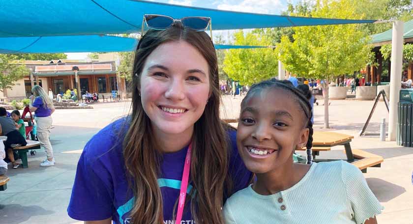 Three happy students walking on a street