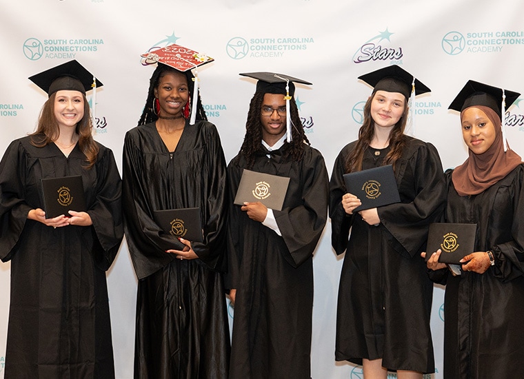 5 graduates of South Carolina Connections Academy hold their diplomas.