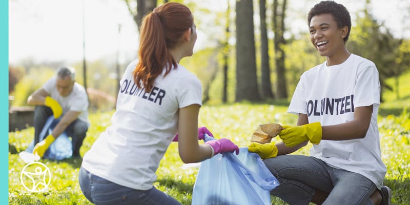 Two teenage students volunteering to clean up a park